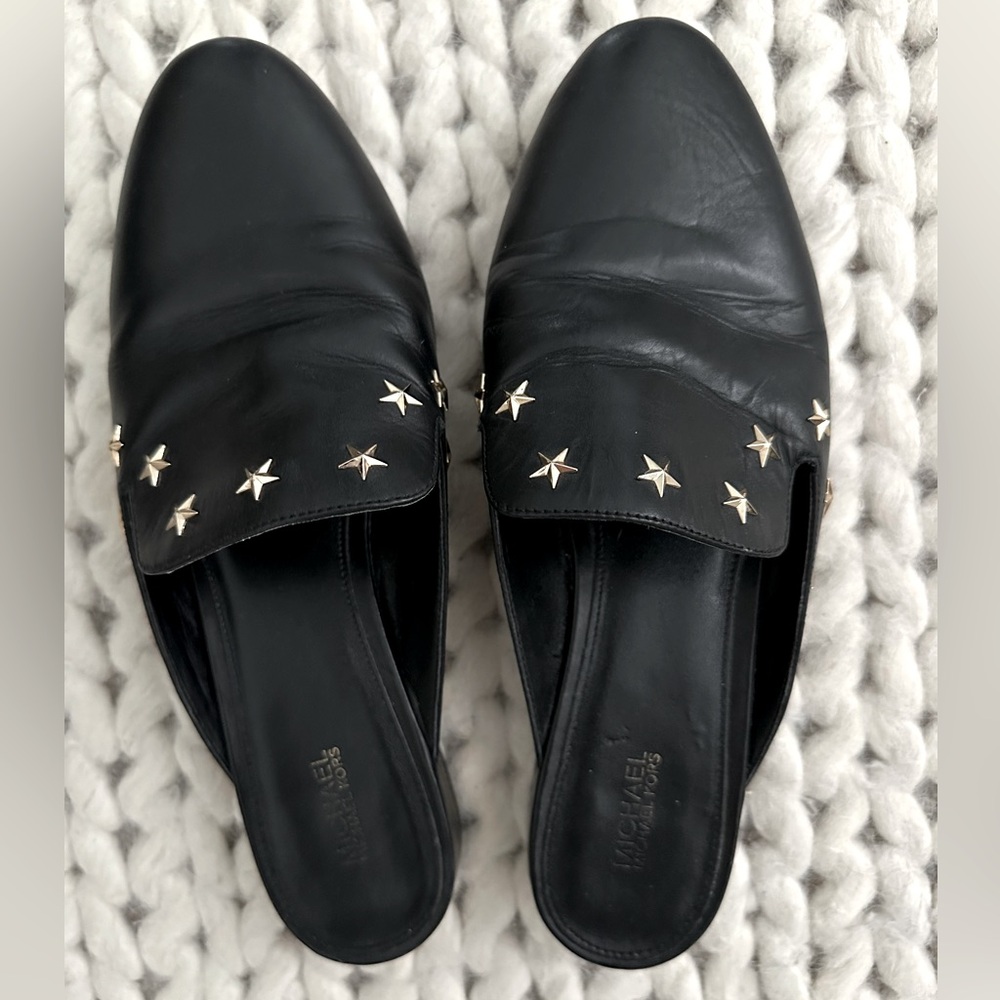 Michael Corr’s black leather slides with gold